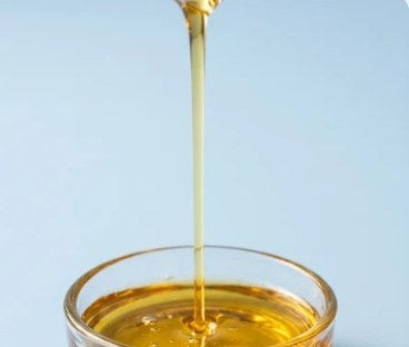Jojoba oil pouring into a glass bowl