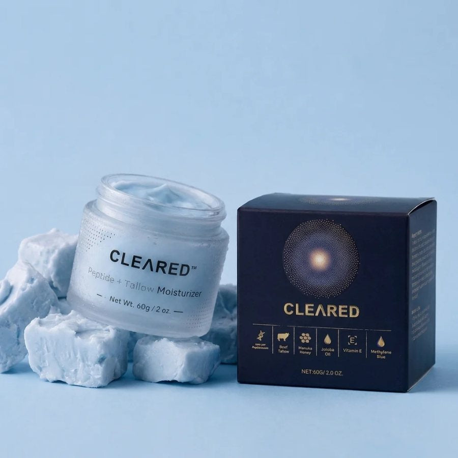 Open CLEARED jar of pale-blue whipped balm beside its navy box with the ingredient panel